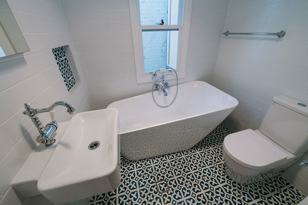 Cette photo montre une salle de bain principale éclectique avec une baignoire indépendante, WC à poser, un carrelage blanc et un mur blanc.