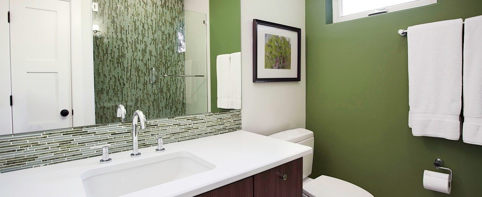 This is an example of a medium sized contemporary ensuite bathroom in Austin with a submerged sink, flat-panel cabinets, dark wood cabinets, engineered stone worktops, an alcove shower, a one-piece toilet, green tiles, glass tiles, green walls and ceramic flooring.