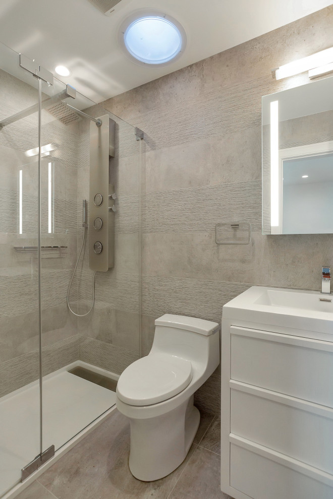 Alcove shower - mid-sized contemporary 3/4 gray tile and ceramic tile ceramic tile and gray floor alcove shower idea in New York with furniture-like cabinets, white cabinets, a one-piece toilet, gray walls, an integrated sink, quartz countertops, a hinged shower door and white countertops