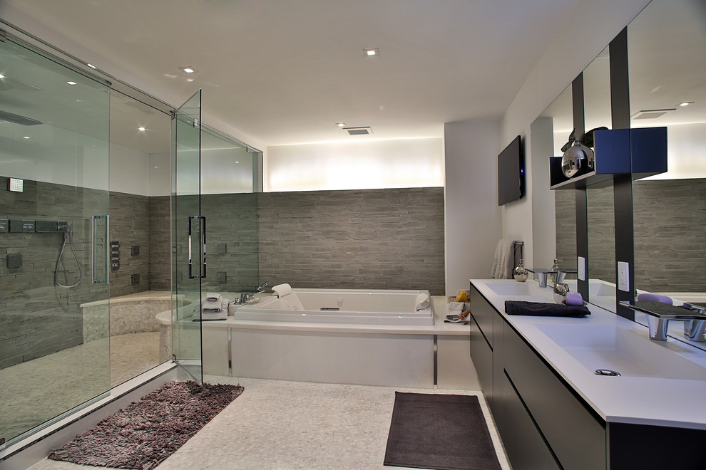 Foto på ett stort funkis en-suite badrum, med ett undermonterad handfat, släta luckor, skåp i mellenmörkt trä, ett platsbyggt badkar, en dusch i en alkov, grå kakel, porslinskakel, vita väggar och klinkergolv i porslin
