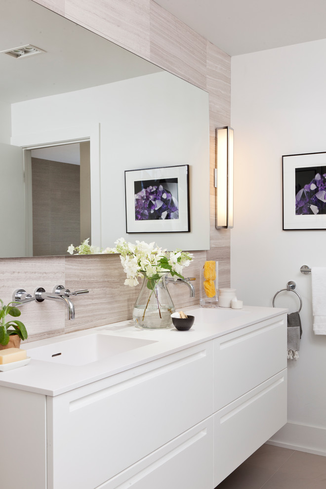 Идея дизайна: главная ванная комната среднего размера в современном стиле с монолитной раковиной, плоскими фасадами, белыми фасадами, столешницей из искусственного камня, бежевой плиткой, каменной плиткой и белыми стенами