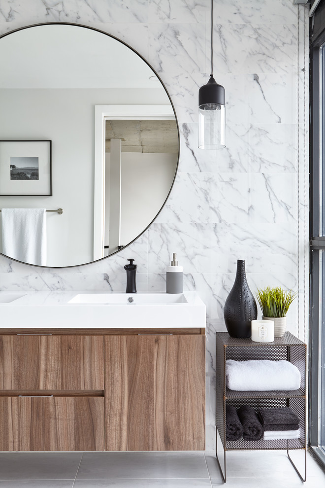 Inspiration for an industrial bathroom in Toronto with flat-panel cabinets, medium wood cabinets, grey tiles, an integrated sink, white floors and white worktops.