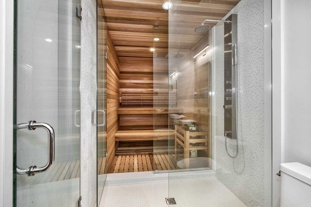 Foto di una grande sauna tradizionale con doccia aperta, piastrelle bianche e porta doccia a battente