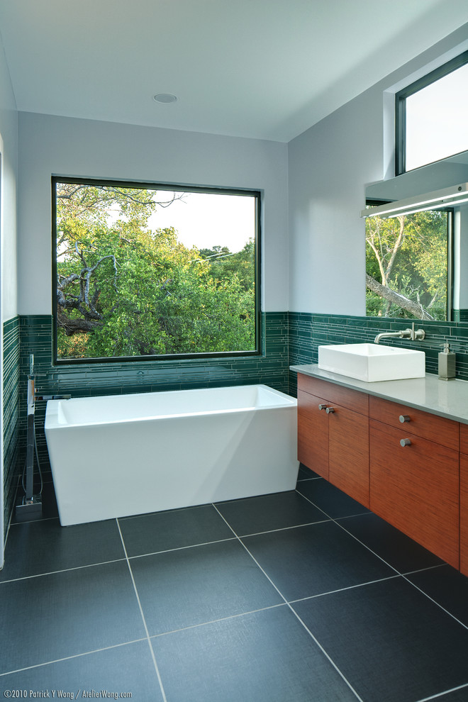 Example of a minimalist freestanding bathtub design in Austin with a vessel sink