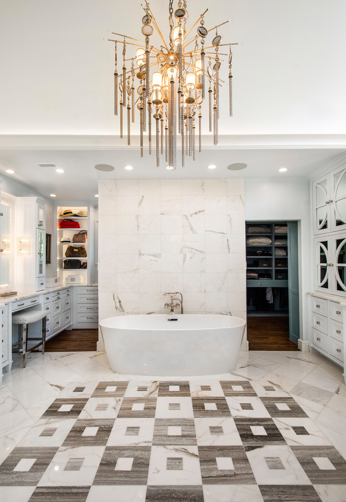This is an example of a large traditional ensuite bathroom in Dallas with recessed-panel cabinets, blue cabinets, a freestanding bath, a corner shower, a two-piece toilet, white tiles, marble tiles, white walls, marble flooring, a submerged sink, multi-coloured floors, a hinged door and white worktops.