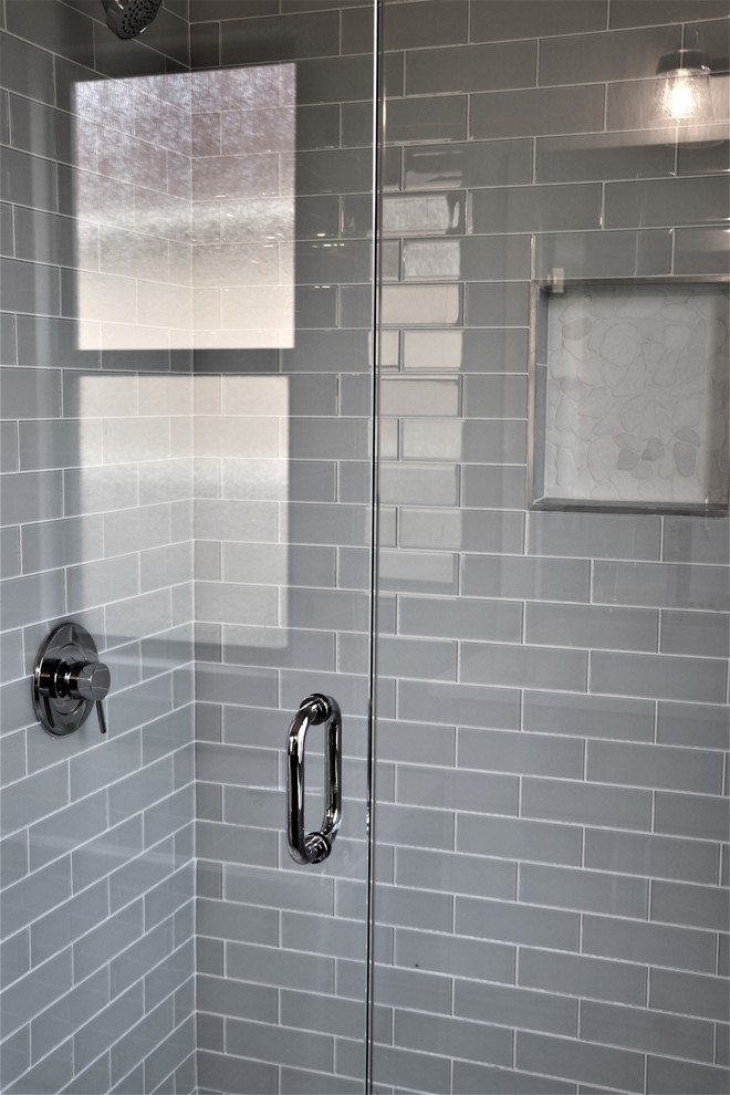 Exemple d'une salle de bain principale tendance avec un placard à porte shaker, des portes de placard grises, une baignoire indépendante, une douche à l'italienne, un carrelage multicolore, du carrelage en marbre, un mur gris, un sol en marbre, une vasque, un plan de toilette en quartz modifié, un sol multicolore et une cabine de douche à porte battante.