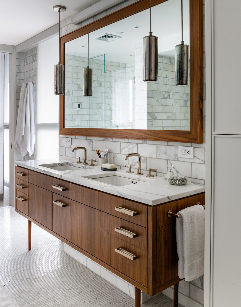 Modernes Badezimmer mit Marmor-Waschbecken/Waschtisch, flächenbündigen Schrankfronten, weißen Fliesen, dunklen Holzschränken und Marmorfliesen in New York