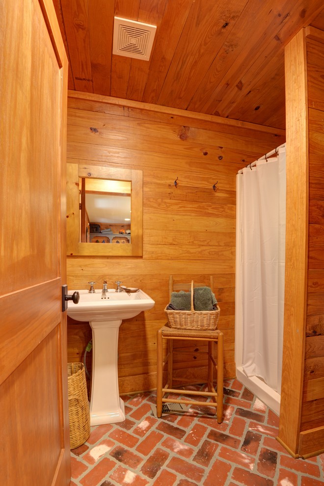 Cette photo montre une petite salle d'eau montagne avec WC séparés, un sol en brique, un lavabo de ferme, un sol rouge et une cabine de douche avec un rideau.