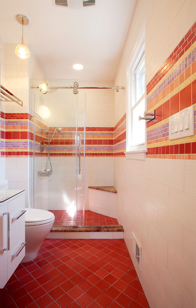 Inredning av ett modernt badrum, med röd kakel, mosaik, släta luckor, vita skåp, en dusch i en alkov och rött golv