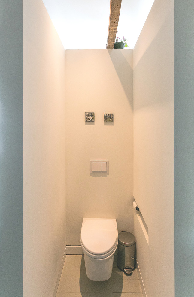 На фото: большой туалет в стиле модернизм с инсталляцией, белой плиткой, белыми стенами, деревянным полом и серым полом