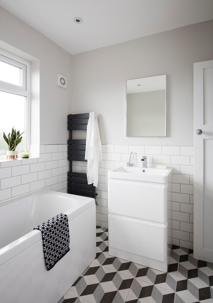 Пример оригинального дизайна: ванная комната в скандинавском стиле с плоскими фасадами, желтыми фасадами, белой плиткой, плиткой кабанчик, серыми стенами, разноцветным полом и окном