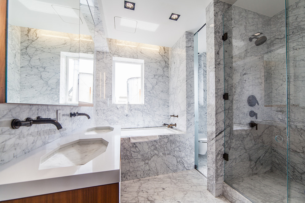 Bild på ett funkis badrum, med ett undermonterad handfat, en dusch i en alkov, en vägghängd toalettstol, grå kakel och ett undermonterat badkar