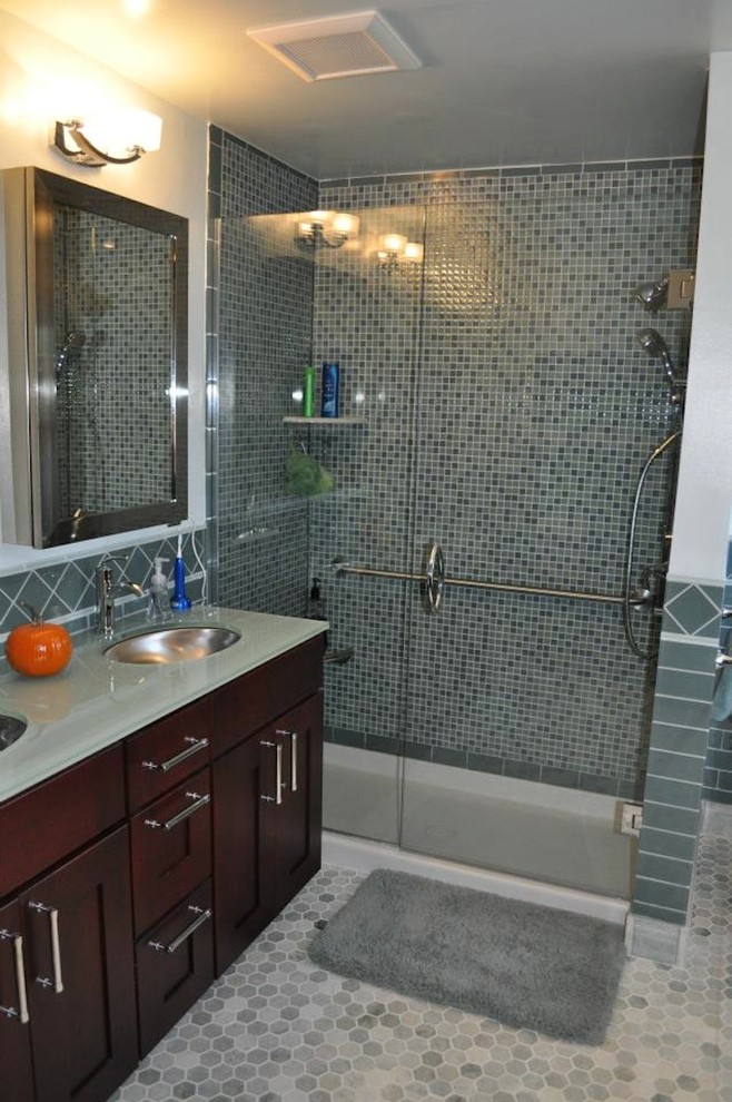 Inspiration for a medium sized contemporary ensuite bathroom in Cincinnati with recessed-panel cabinets, dark wood cabinets, an alcove shower, a one-piece toilet, grey tiles, ceramic tiles, white walls, mosaic tile flooring, a submerged sink and glass worktops.
