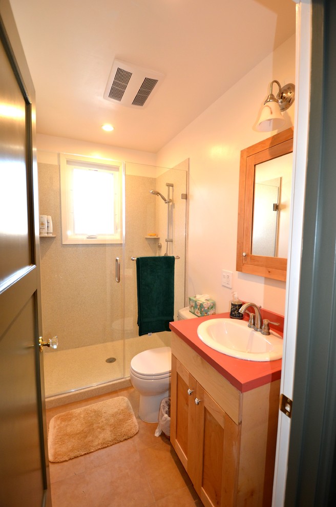 サンフランシスコにあるお手頃価格の小さなコンテンポラリースタイルのおしゃれなバスルーム (浴槽なし) (落し込みパネル扉のキャビネット、淡色木目調キャビネット、オープン型シャワー、分離型トイレ、ベージュのタイル、セラミックタイル、白い壁、クッションフロア、オーバーカウンターシンク、ラミネートカウンター) の写真
