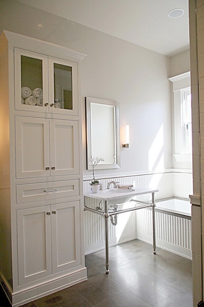 Пример оригинального дизайна: главная ванная комната среднего размера в классическом стиле с фасадами в стиле шейкер, белыми фасадами, ванной в нише, белой плиткой, керамической плиткой, бежевыми стенами, полом из керамогранита, консольной раковиной, мраморной столешницей и серым полом