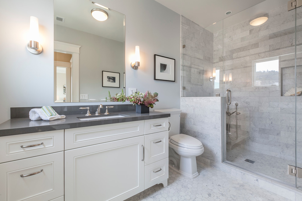 Diseño de cuarto de baño clásico renovado con armarios con paneles empotrados, encimera de cuarzo compacto, ducha doble, baldosas y/o azulejos grises, baldosas y/o azulejos de piedra y suelo de mármol