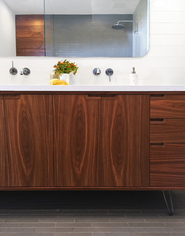 Cette image montre une salle de bain principale design en bois brun de taille moyenne avec un placard en trompe-l'oeil, une douche d'angle, WC suspendus, un carrelage blanc, des carreaux de céramique, un mur blanc et un lavabo encastré.