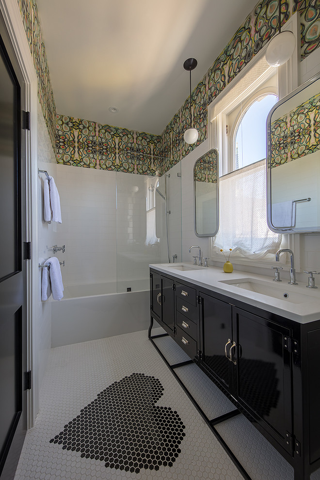 Источник вдохновения для домашнего уюта: ванная комната среднего размера в стиле неоклассика (современная классика) с черными фасадами, ванной в нише, душем над ванной, белой плиткой, разноцветными стенами, полом из мозаичной плитки, врезной раковиной, открытым душем, белой столешницей и фасадами с утопленной филенкой