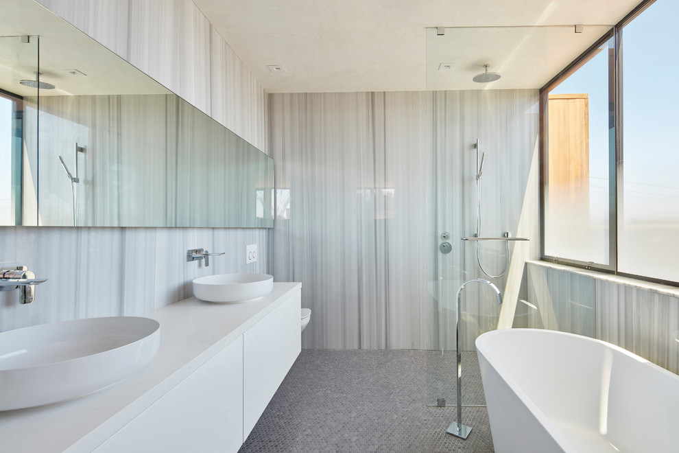 Cette photo montre une salle de bain principale tendance avec un placard à porte plane, des portes de placard blanches, une baignoire indépendante, une douche à l'italienne, un sol en carrelage de terre cuite, une vasque, un sol gris et aucune cabine.