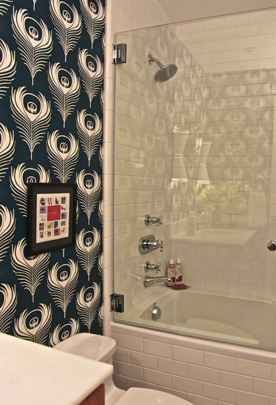 Cette image montre une salle d'eau traditionnelle en bois clair avec un lavabo posé, un placard à porte plane, une baignoire posée, un combiné douche/baignoire, WC séparés, un carrelage blanc, un carrelage métro et un mur vert.