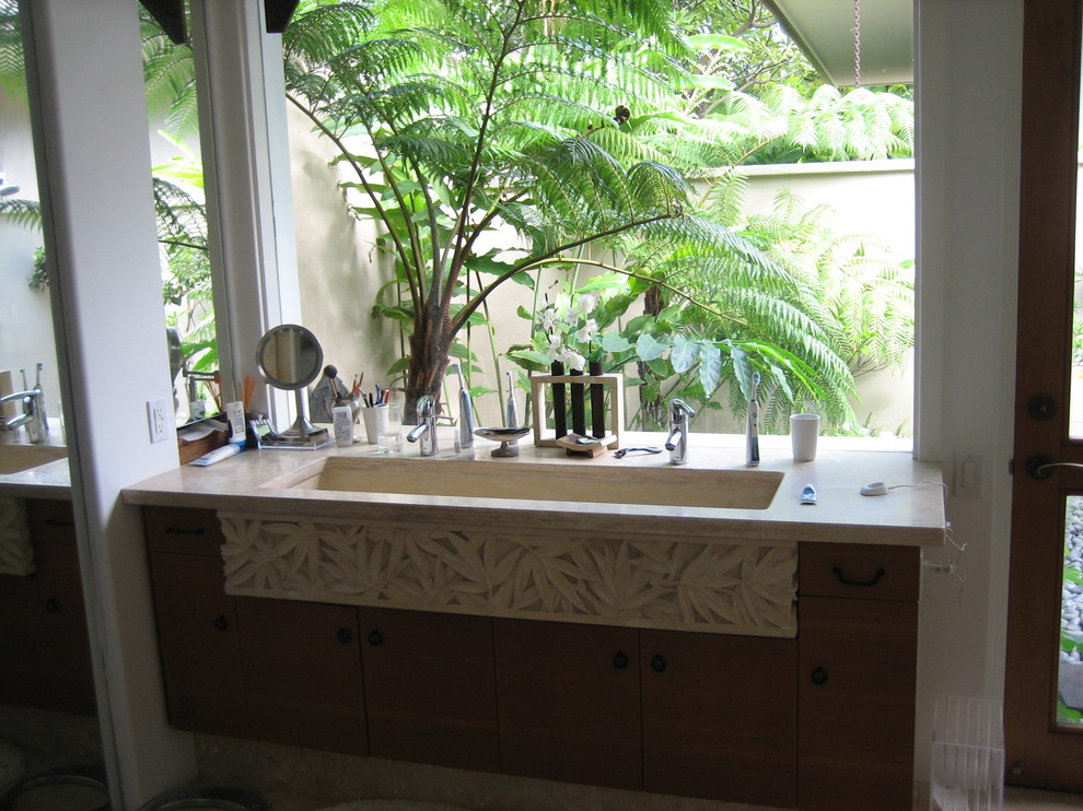 Inspiration för ett mellanstort tropiskt en-suite badrum, med ett undermonterad handfat, släta luckor, skåp i mellenmörkt trä, bänkskiva i kalksten, beige kakel, stenkakel och travertin golv