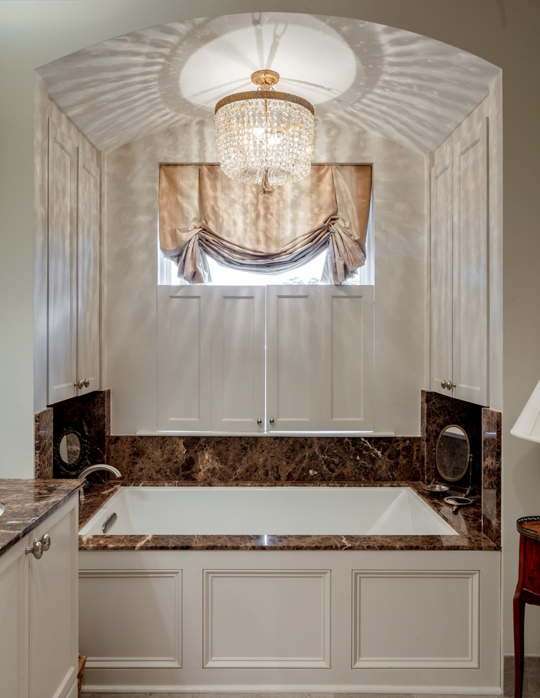 Idee per una stanza da bagno padronale classica di medie dimensioni con ante con riquadro incassato, ante bianche, vasca sottopiano, pareti bianche, top in granito e top marrone