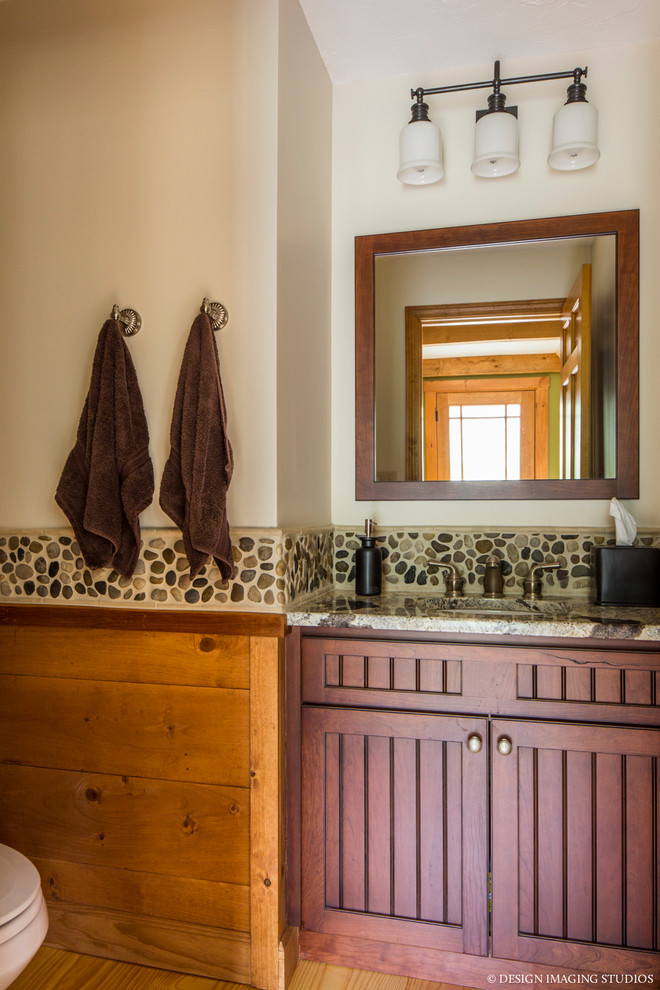 На фото: ванная комната в стиле кантри с фасадами с филенкой типа жалюзи, темными деревянными фасадами, разноцветной плиткой, галечной плиткой, бежевыми стенами, светлым паркетным полом и врезной раковиной