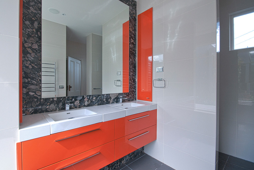 Foto på ett stort funkis en-suite badrum, med släta luckor, orange skåp, ett platsbyggt badkar, en dusch i en alkov, beige kakel, keramikplattor, beige väggar, klinkergolv i porslin, ett integrerad handfat, bänkskiva i kvarts, grått golv och med dusch som är öppen