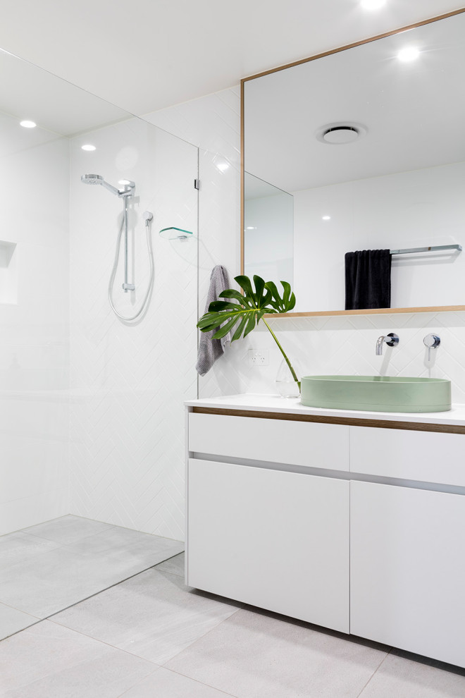 Идея дизайна: ванная комната в современном стиле с плоскими фасадами, белыми фасадами, душем без бортиков, белой плиткой, настольной раковиной, серым полом и белой столешницей