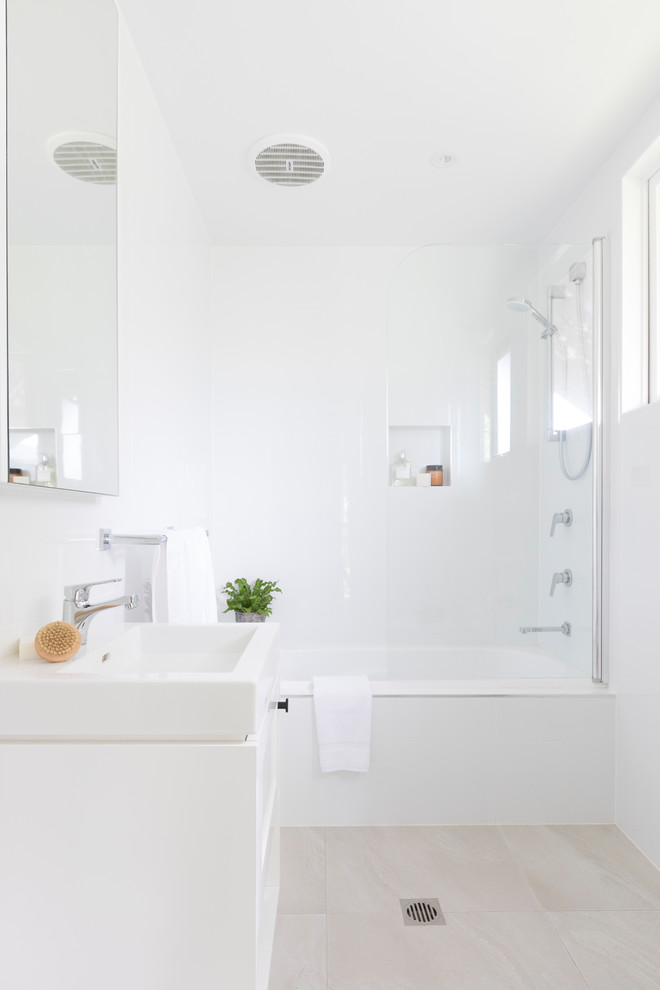 Inspiration för ett funkis vit vitt badrum med dusch, med släta luckor, vita skåp, ett badkar i en alkov, en dusch/badkar-kombination, vita väggar, ett fristående handfat, beiget golv och dusch med gångjärnsdörr