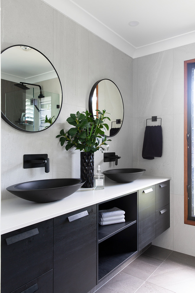 Maritimes Badezimmer mit flächenbündigen Schrankfronten, schwarzen Schränken, grauen Fliesen, grauer Wandfarbe, Aufsatzwaschbecken, grauem Boden und weißer Waschtischplatte in Sunshine Coast