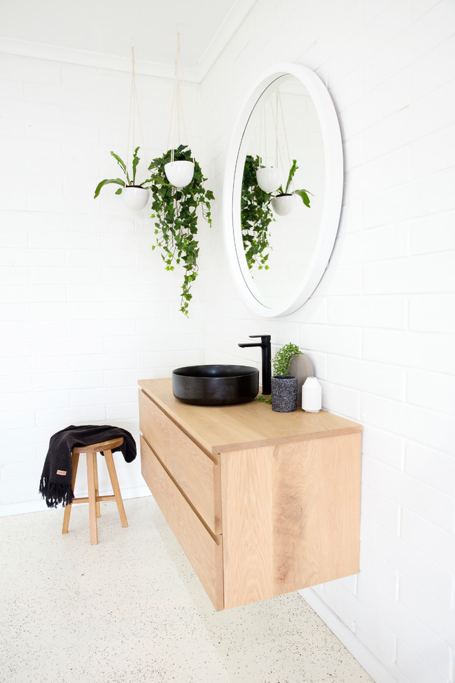 Aménagement d'une salle de bain moderne avec un carrelage blanc, un mur blanc, un plan vasque et un plan de toilette en bois.
