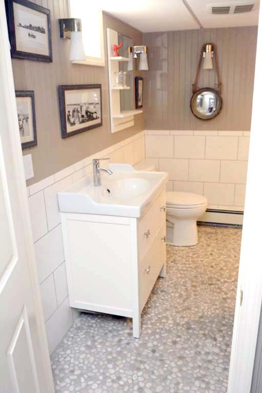 Foto på ett mellanstort maritimt badrum med dusch, med släta luckor, vita skåp, en dusch i en alkov, en toalettstol med separat cisternkåpa, vit kakel, porslinskakel, grå väggar, klinkergolv i småsten, ett integrerad handfat, bänkskiva i akrylsten, grått golv och med dusch som är öppen