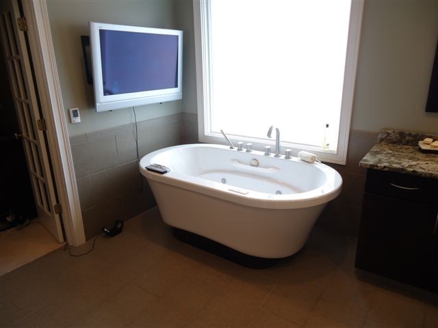 Example of a minimalist master beige tile and ceramic tile ceramic tile freestanding bathtub design in Indianapolis with flat-panel cabinets, dark wood cabinets, granite countertops and beige walls