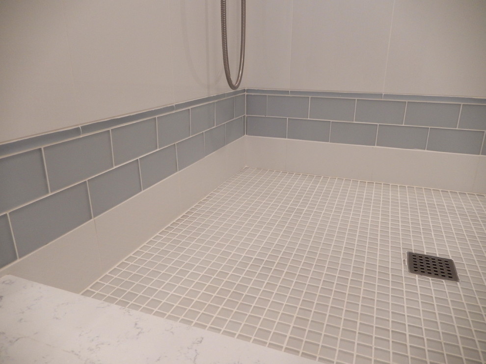 This is an example of a medium sized nautical shower room bathroom in New York with beaded cabinets, white cabinets, an alcove shower, blue tiles, white tiles, metro tiles, porcelain flooring, a submerged sink, marble worktops, white floors and a hinged door.