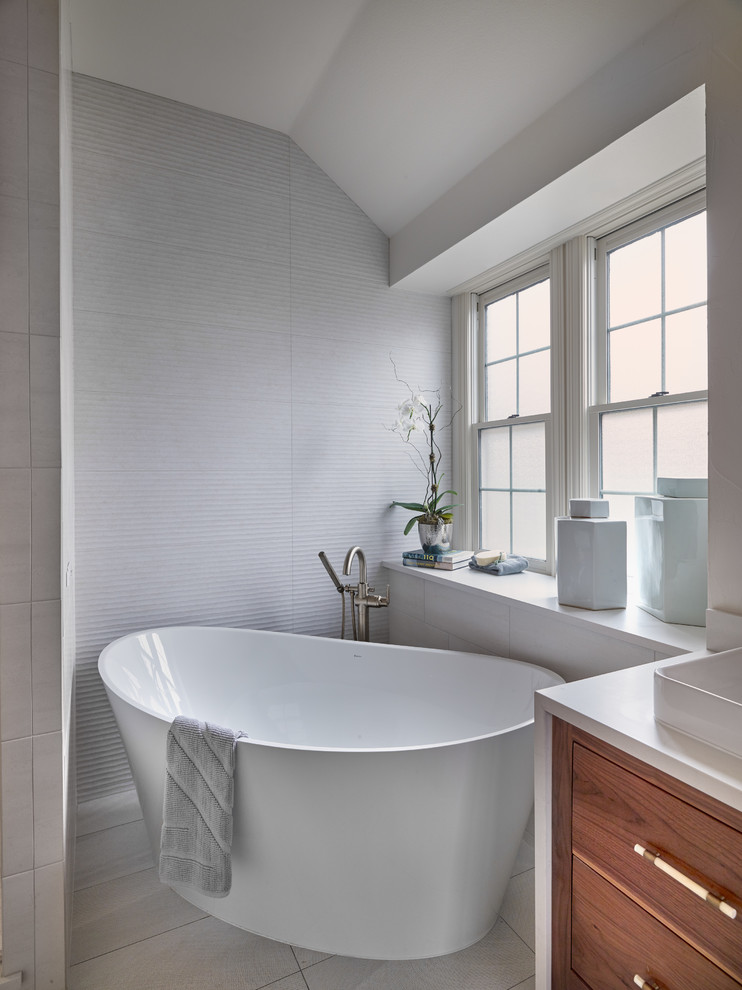 Bathroom - mid-sized eclectic master white tile and porcelain tile porcelain tile and gray floor bathroom idea in Dallas with flat-panel cabinets, medium tone wood cabinets, a one-piece toilet, white walls, a vessel sink, quartz countertops, a hinged shower door and white countertops