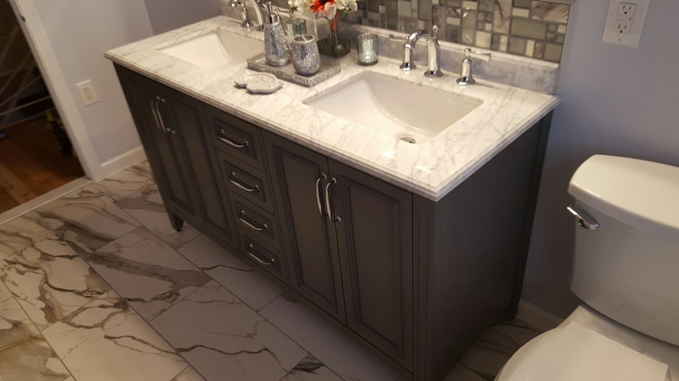 Design ideas for a medium sized contemporary bathroom in Philadelphia with raised-panel cabinets, grey cabinets, an alcove bath, a shower/bath combination, a two-piece toilet, porcelain tiles, blue walls, porcelain flooring, a submerged sink and marble worktops.