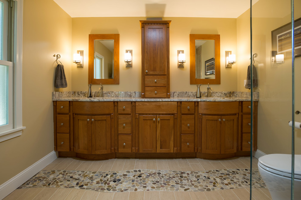 Idéer för att renovera ett mellanstort amerikanskt en-suite badrum, med ett undermonterad handfat, skåp i shakerstil, skåp i mellenmörkt trä, granitbänkskiva, en hörndusch, en toalettstol med hel cisternkåpa, beige kakel, keramikplattor, gula väggar och klinkergolv i porslin