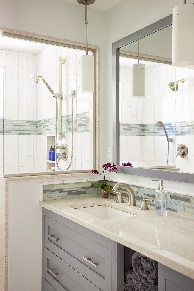 Свежая идея для дизайна: главная ванная комната среднего размера в стиле неоклассика (современная классика) с серыми фасадами, разноцветной плиткой, белыми стенами, врезной раковиной, плоскими фасадами, двойным душем, плиткой из листового стекла, полом из галечной плитки, столешницей из искусственного кварца, серой столешницей и душем с распашными дверями - отличное фото интерьера