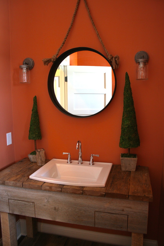 Exemple d'une petite salle d'eau craftsman en bois brun avec un lavabo posé, un plan de toilette en bois, WC séparés, un mur rouge et parquet foncé.
