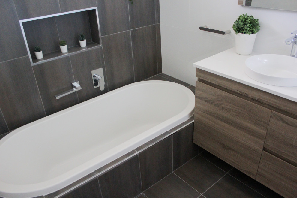 Inspiration for a small modern family bathroom in Perth with flat-panel cabinets, dark wood cabinets, a built-in bath, a corner shower, white tiles, ceramic tiles, white walls, porcelain flooring, a vessel sink, engineered stone worktops, brown floors, a hinged door and white worktops.