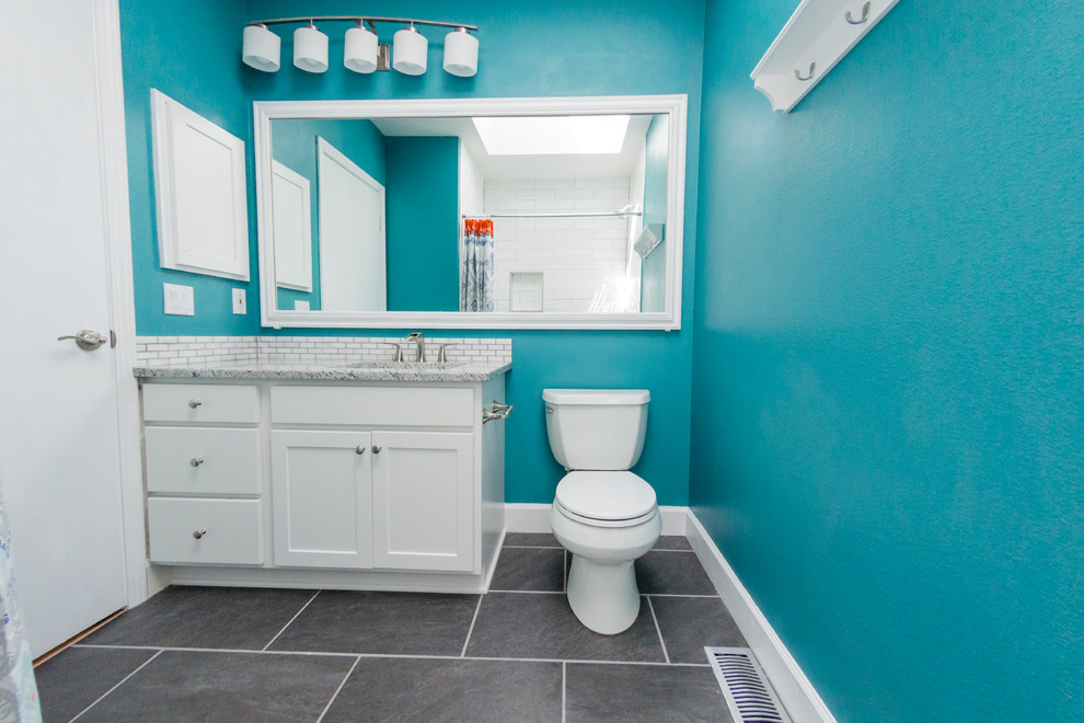 Immagine di una stanza da bagno con doccia classica di medie dimensioni con ante in stile shaker, ante bianche, WC monopezzo, piastrelle bianche, piastrelle diamantate, pareti blu, lavabo sottopiano, top in granito e pavimento grigio