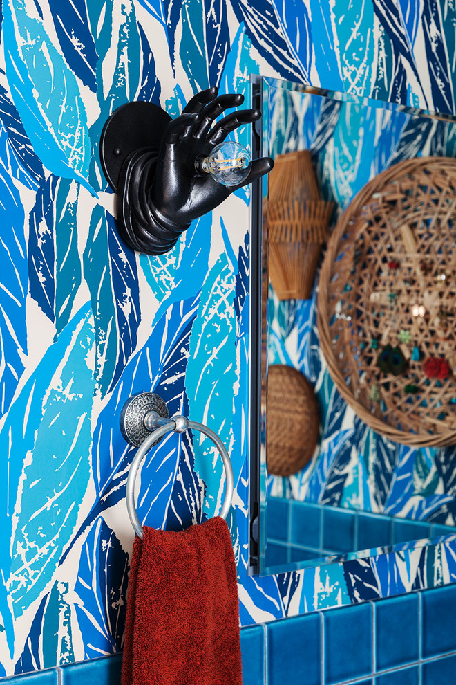 Cette image montre une petite salle d'eau bohème en bois clair avec un placard à porte plane, une douche d'angle, WC séparés, un carrelage bleu, des carreaux de céramique, un mur multicolore, un sol en carrelage de céramique, un lavabo intégré, un plan de toilette en surface solide, un sol bleu et une cabine de douche à porte battante.