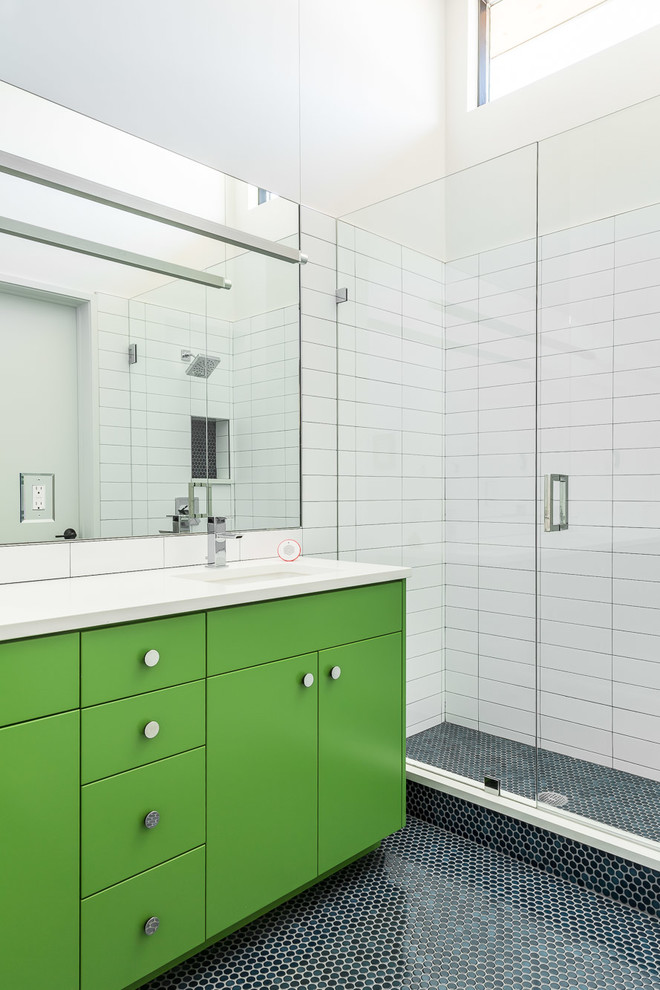 Example of a mid-sized minimalist kids' white tile and ceramic tile ceramic tile and blue floor alcove shower design in Denver with flat-panel cabinets, green cabinets, white walls, an undermount sink, quartz countertops, a hinged shower door and white countertops