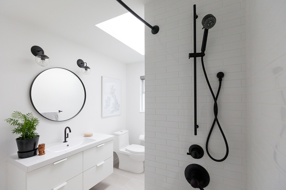 Exempel på ett litet klassiskt vit vitt badrum, med släta luckor, vita skåp, en dusch i en alkov, vit kakel, tunnelbanekakel, vita väggar, svart golv och dusch med duschdraperi