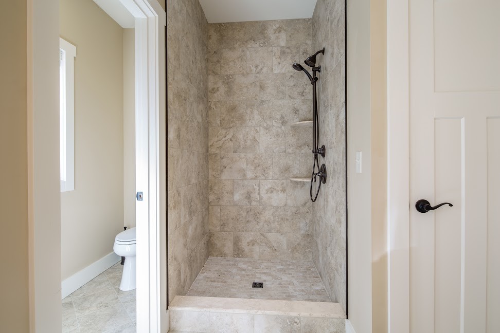 Exemple d'une salle de bain principale craftsman en bois clair de taille moyenne avec un placard à porte shaker, une baignoire en alcôve, une douche d'angle, WC à poser, un carrelage marron, des carreaux de céramique, un mur beige, un sol en carrelage de céramique, un lavabo encastré et un plan de toilette en granite.