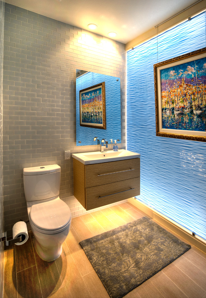 Exemple d'une salle de bain moderne en bois clair de taille moyenne avec un lavabo suspendu, un placard à porte plane, un plan de toilette en quartz, une baignoire indépendante, WC à poser, un carrelage marron, des carreaux de porcelaine, un mur gris et un sol en carrelage de porcelaine.