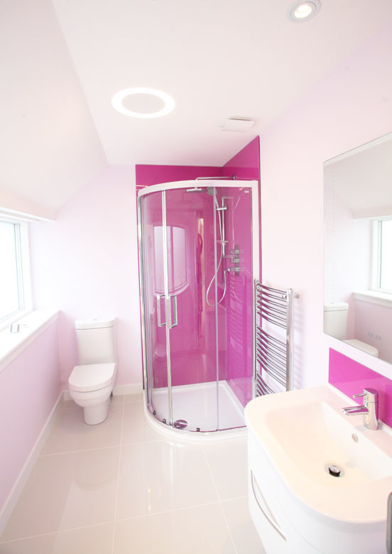 На фото: главная ванная комната в современном стиле с подвесной раковиной, плоскими фасадами, белыми фасадами, угловым душем, унитазом-моноблоком, розовой плиткой, плиткой из листового стекла, белыми стенами и полом из керамогранита с