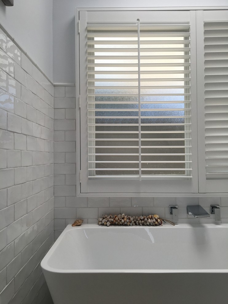 Foto på ett mellanstort funkis badrum för barn, med skåp i shakerstil, vita skåp, ett fristående badkar, vit kakel, perrakottakakel, vita väggar, klinkergolv i keramik och bänkskiva i terrazo