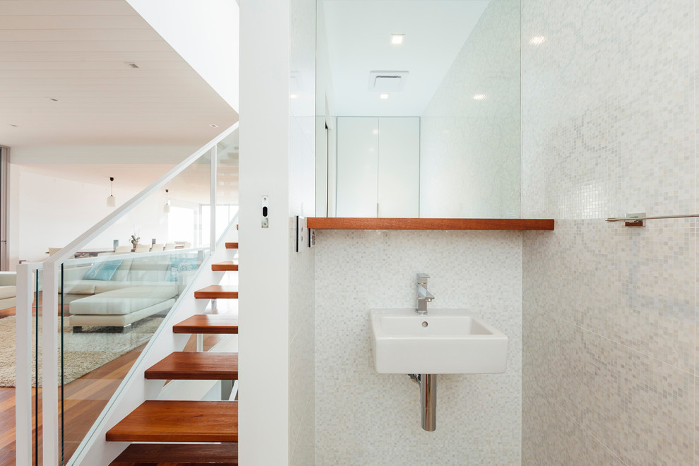 Photo of a small modern bathroom in Sydney with a one-piece toilet, white tiles, mosaic tiles, white walls, a wall-mounted sink and wooden worktops.
